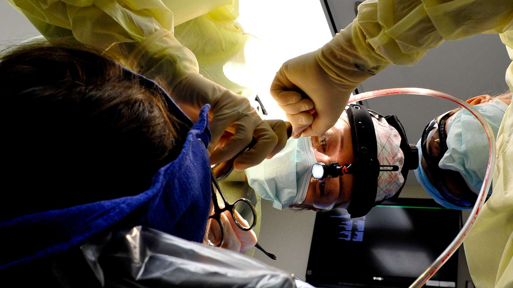 ORAL AND MAXILLOFACIAL SURGEON WORKING ON A PATIENT